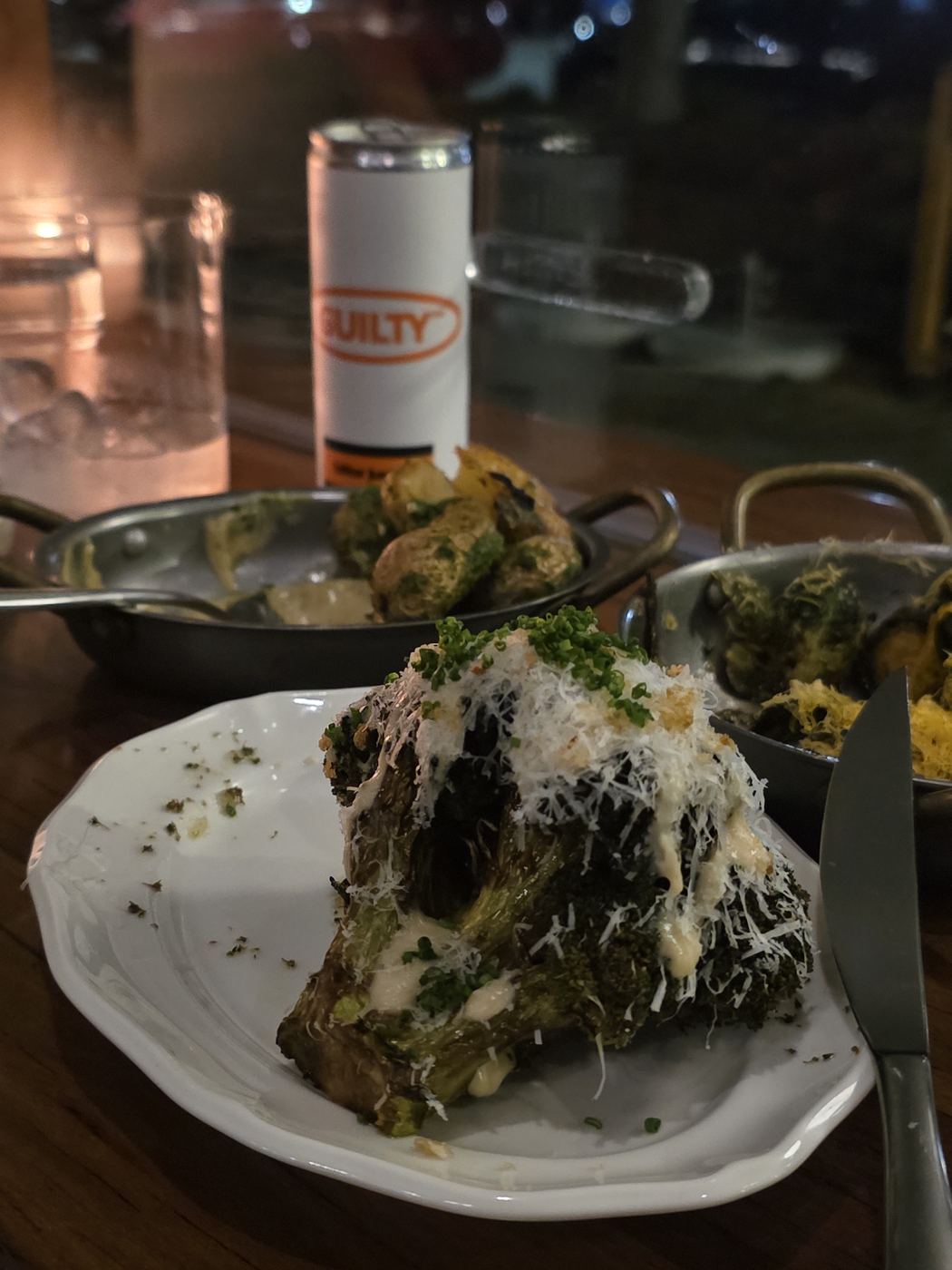 A Guilty can beside a plated dish at a restaurant